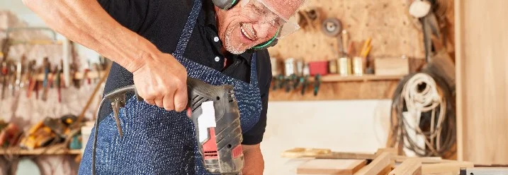 Person baut mit Bohrer Holz zusammen